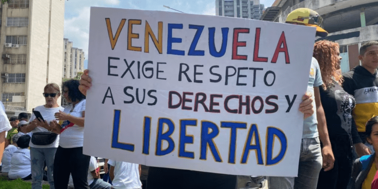 Una mujer muestra un cartel donde exige mejoras salariales al gobierno de Venezuela, durante una movilización por el Día del Trabajador en Caracas, el 1 de mayo de 2024.