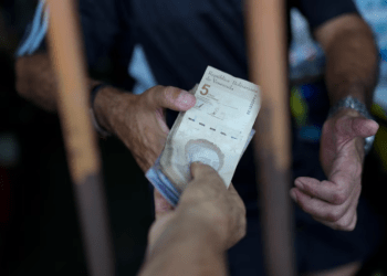 Un cliente paga en un abasto en el mercado periférico de Valencia el 1 de febrero de 2024. El BCV publicó que la inflación de mayo fue de 1,5 %.