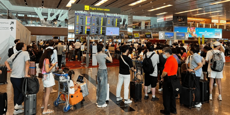 Los pasajeros formaron largas colas en el aeropuerto de Singapur debido a una importante interrupción del servicio informático en Singapur el 19 de julio de 2024. (Foto de Roslan RAHMAN / AFP)