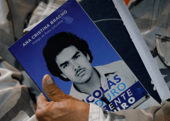 Un asistente al estreno de una película biográfica del presidente Nicolás Maduro sostiene un folleto informativo de la obra, donde se ve al mandatario cuando era joven, en Caracas, este 14 de julio de 2024.