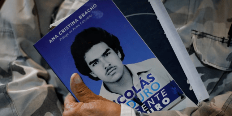 Un asistente al estreno de una película biográfica del presidente Nicolás Maduro sostiene un folleto informativo de la obra, donde se ve al mandatario cuando era joven, en Caracas, este 14 de julio de 2024.