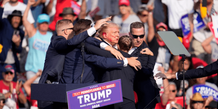 El candidato presidencial republicano y expresidente Donald Trump recibe ayuda para salir del escenario en un evento de campaña en Butler, Pensilvania, el 13 de julio de 2024.