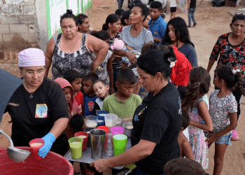 La gente recibe alimentos de Carolina Leal, directora y fundadora de la fundación Alimentando sueños, en Maracaibo, Venezuela, 12 de junio de 2024.
