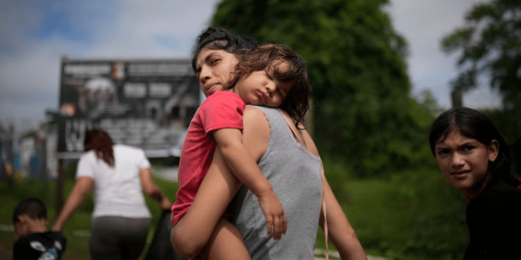 La migrante venezolana Naiber Zerpa sostiene a su hijo Mathías Márquez cuando llegan a un campamento temporal después de cruzar caminando el Tapón del Darién desde Colombia, en Lajas Blancas, Panamá, el viernes 28 de junio de 2024.
