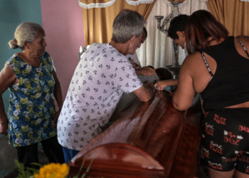 Familiares de Víctor Bustos, de 35 años, lloran mientras velan sus restos mortales en su vivienda, en Valencia, el 31 de julio de 2024. El hombre murió en las protestas por el resultado electoral en Venezuela, reprimidas por la policía, según sus cercanos.