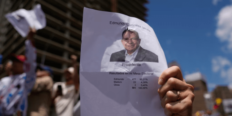 ARCHIVO - Un hombre sostiene una copia del recuento de votos de una mesa de votación con una imagen del candidato presidencial Edmundo González, durante una manifestación en Caracas, Venezuela, el sábado 17 de agosto de 2024.