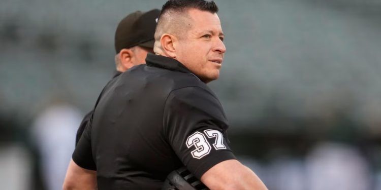 El árbitro venezolano Carlos Torres conversa con un colega antes del juego entre los Marineros de Seattle y los Atléticos de Oakland en California, el 18 de septiembre de 2024. Torres será árbitro principal del primer juego de la Serie Mundial. (ARCHIVO: AP)