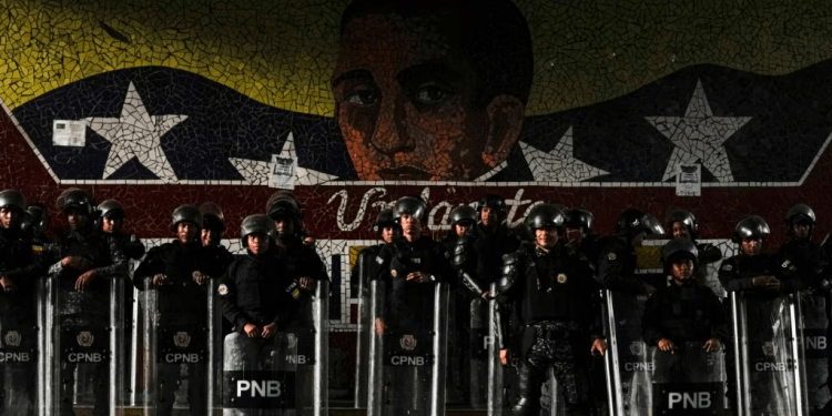 Funcionarios de la Policía Nacional Bolivariana se forman frente a un mural del Libertador Simón Bolívar en Caracas, el 31 de julio de 2024, después de dos días de protestas contra los resultados de la elección presidencial en Venezuela.