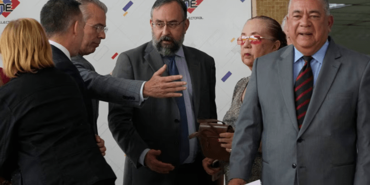 El rector del CNE, Juan Carlos Del Pingo, tercero en la foto de izquierda a derecha, saluda a miembros de la comisión de la primaria opositora en la sede del poder electoral en Caracas, el 25 de septiembre de 2023.
