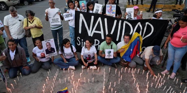 Familiares de venezolanos detenidos encienden velas durante una vigilia frente a la sede del Servicio Bolivariano de Inteligencia Nacional (SEBIN) conocida como "Helicoide", en Caracas, Venezuela, el 27 de noviembre de 2024. REUTERS/Gaby Oraa