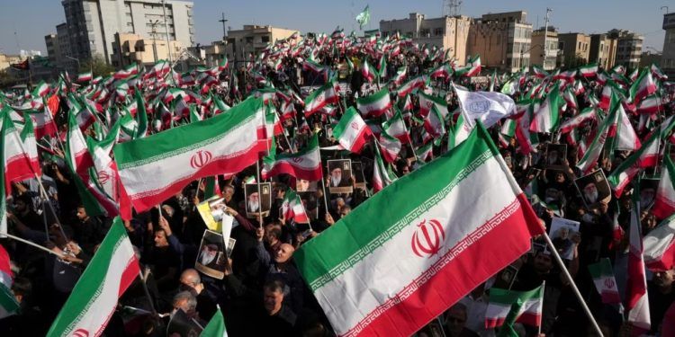 ARCHIVO - Manifestantes progubernamentales ondean banderas iraníes durante las protestas por la muerte de Mahsa Amini, una mujer de 22 años detenida por la policía moral del país, en Teherán, Irán, el 25 de septiembre de 2022.