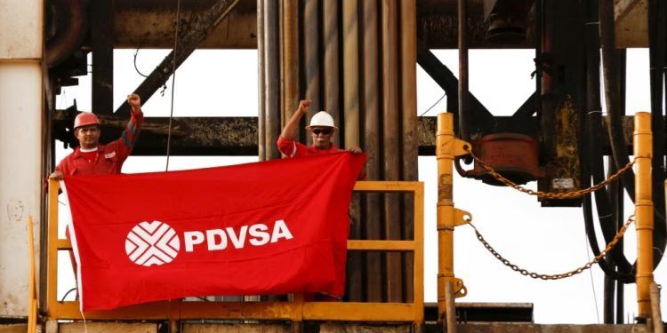 Trabajadores petroleros de Venezuela sostienen una bandera con el logo de PDVSA en una instalación de la Faja del Orinoco, en Anzoátegui, el 16 de abril de 2023. (ARCHIVO: REUTERS)