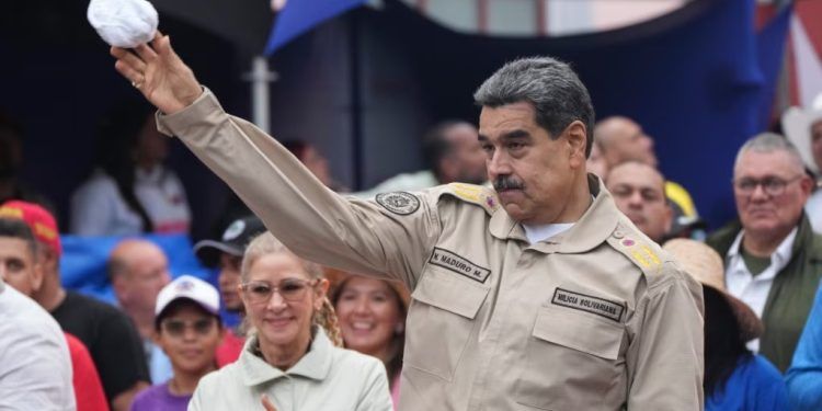 El presidente venezolano Nicolás Maduro lanza un pañuelo a simpatizantes durante una concentración oficialista en Caracas por el aniversario 165 de la Batalla de Santa Inés, el 10 de diciembre de 2024.