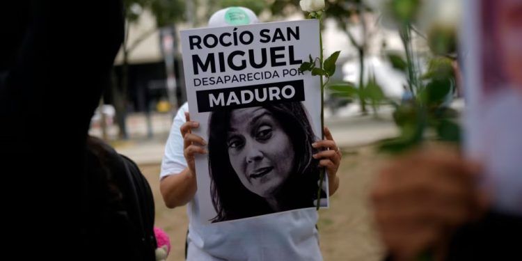 ARCHIVO - Una manifestante opositora sostiene un cartel con la imagen de la activista Rocío San Miguel durante una protesta en Caracas, el 18 de julio de 2024.