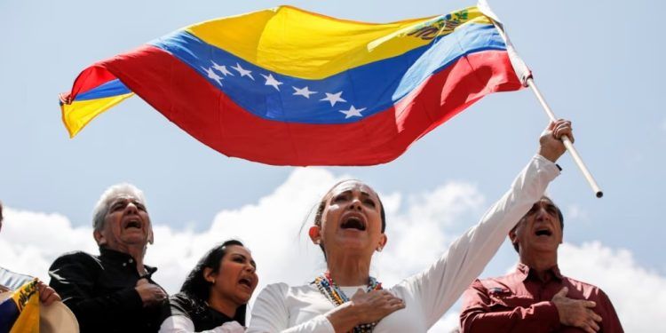 ARCHIVO - La dirigente opositora María Corina Machado ondea una bandera de Venezuela durante una protesta el 17 de agosto de 2024, en Caracas.