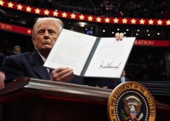 El presidente Donald Trump firma una orden ejecutiva mientras asiste a un desfile inaugural presidencial en el Capital One Arena, el 20 de enero de 2025, en Washington.