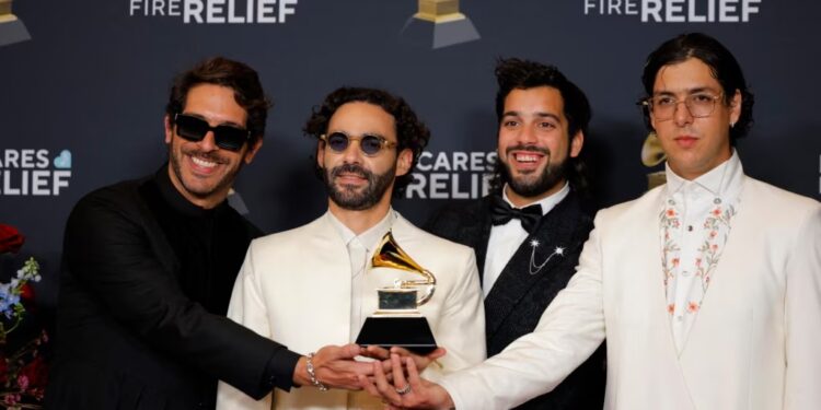 Los miembros de la banda venezolana Rawayana pasan con un premio Grammy tras ganar la categoría a mejor álbum latino de rock o música alternativa, en Los Ángeles, Estados Unidos, el 2 de febrero de 2025.